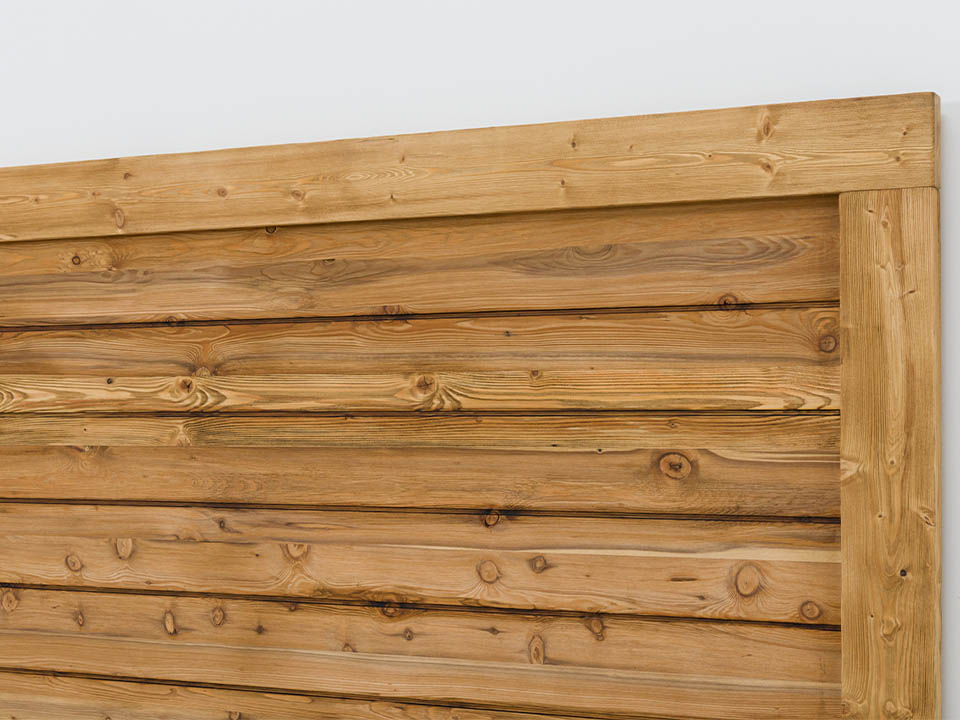 łóżko z drewnianym zagłówkiem